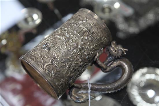 A mid-19th century Chinese silver mug, the body featuring warriors fighting to one side, with inscribed shield plaque H.13cm.